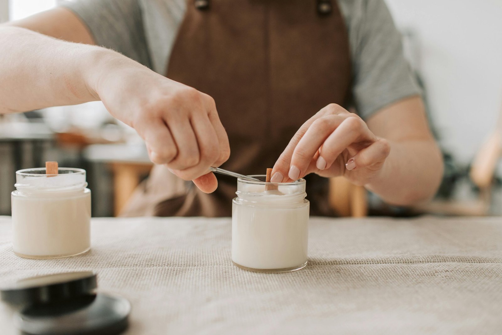 Visual example of brand storytelling: close-up of a candle maker placing a wooden wick in a handmade soy candle — authentic, behind-the-scenes content ideal for digital marketing and social media branding.
